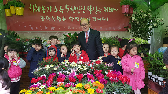 박준식 조합장이 ‘새봄맞이 꽃 큰잔치 개장식’을 맞아 어린이들과 기념촬영을 하고 있다.