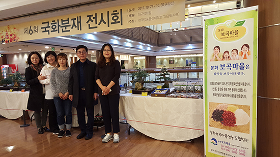 김건우 단장(오른쪽 두 번째)이 지난해 10월 27일부터 4일간 대구백화점에서 개최된 ‘제6회 국화분재 전시회’에서 봉화보곡마을 잡곡을 홍보하고 있다.
