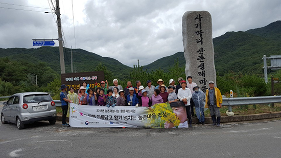 지난 14일 한국화훼협회 회원들이 충북괴산에서 주민들과 꽃을 심고 있다.