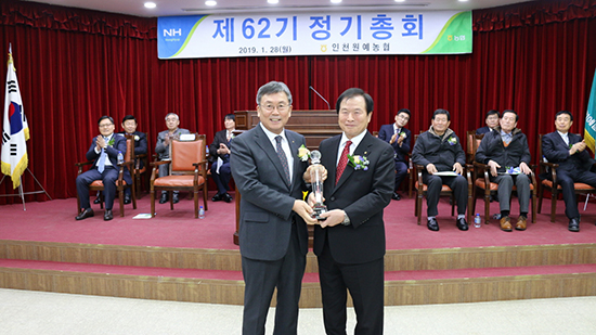 이기용 조합장이 이종근 농협중앙회 이사(부천시흥원예농협 조합장)로부터 상호금융 달성탑을 수상하고 있다.