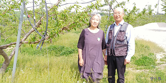 박재훈·이순열 부부가 지난 8일 도도한 복숭아 칠성농장을 배경으로 미소를 짓고 있다.