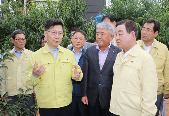 김현수 농식품부 장관(왼쪽 두번째)이 지난 4일 권오영 예산능금농협 조합장(오른쪽 세번째)과 사과재배 농가를 방문하고 있다.