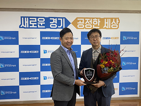 ‘2020 농업과학기술인상’ 최우수상을 수상한 경기도농업기술원의 김시열 지도관(오른쪽)이 상패를 전달받고 기념촬영을 하고 있다.