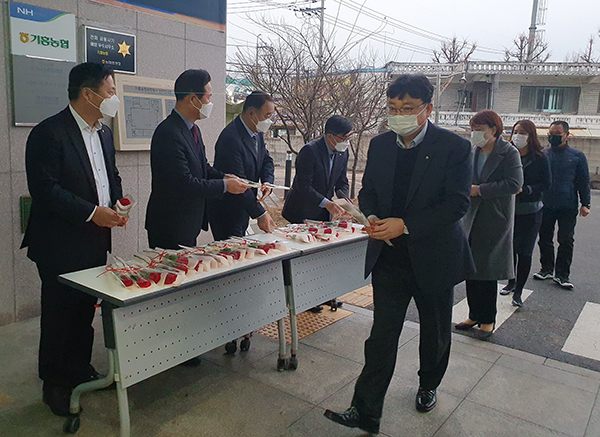 농협중앙회 경기검사국 감사반원들이 지난달 26일 기흥농협에서 출근하는 직원들에게 꽃을 전달하고 있다.