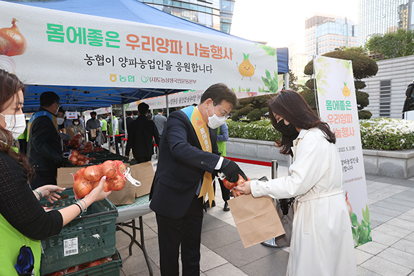 이재식 농협중앙회 부회장이 지난 3일 오후 서울 중구 농협중앙회 본관 광장에서 개최된 양파 소비촉진 나눔행사에서 농협을 방문하는 고객과 임직원을 대상으로 햇양파 1망(/1.5kg)씩 증정하고 있다.