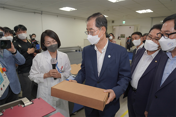 한덕수 국무총리가 한국식품산업클러스터 식품패키징센터에서 가동 중인 식품포장 시험장비의 원리에 대해 식품진흥원 배민정 부장으로부터 설명을 듣고 있다.