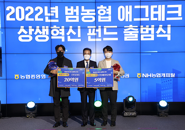 이성희 농협중앙회장이 지난달 28일 서울 동대문 메리어트 호텔에서 열린 ‘애그테크 상생혁신펀드 출범식'에서 1, 2호 투자기업인 (주)에이오팜 곽호재 대표, (주)긴트 김용현 대표에게 투자금을 전달하고 있다.