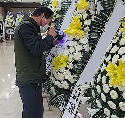 지난 3일 전북 한 장례식장에서 새로 들어온 화환에 전날 묻혀둔 형광물질을 확인하고 있는 모습.