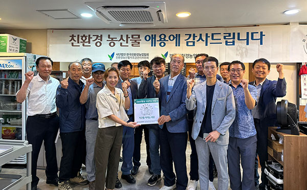 경남친환경농업협회가 경남 고성 ‘육마루’에서 ‘지구를 지키는 식당’ 현판식을 갖고 단체사진을 촬영하고 있다.