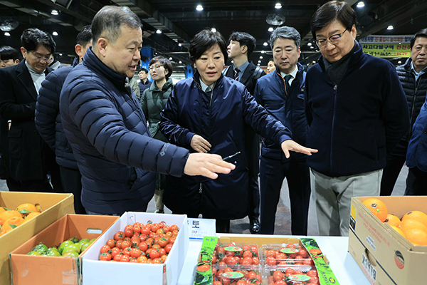 송미령 장관(가운데)이 이원석 중앙청과 대표(왼쪽)이사에게 출하된 농산물을 설명받고 있다.