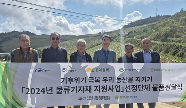 강원도 강릉 안반데기 배추 밭에서 진행된 2024년 물류기자재 지원사업 토양영양제 전달식에서 주요 관계자들이 기념촬영을 하고 있다.