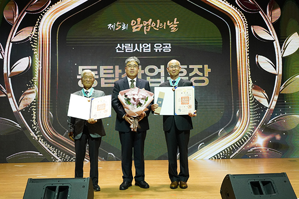 동탑산업훈장을 받은 한치복 이사장(왼쪽)과 김종원 회장(오른쪽)이 임상섭 산림청장(가운데)과 기념촬영을 하고 있다.