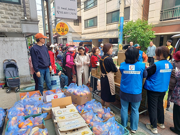 서울시농수산식품공사가 송파구에서 진행한 ‘사랑의 과일 나눔’ 행사에서 어르신들에게 신선 과일을 전달하고 있다.