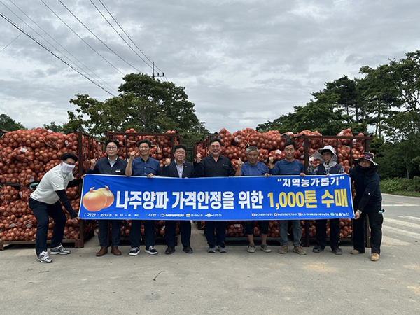 양파 수매식 현장에서 관계자들이 기념 촬영을 하고 있다.
